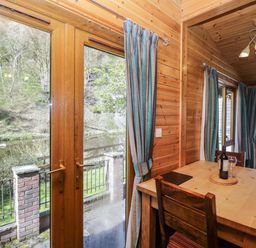 A dining room with a table and chairs at Elm Lodge in Keswick