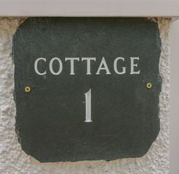 A sign with the text cottage 1 on a wall at Garden Cottage No 1 in Keswick