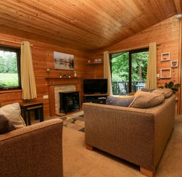 A living room with a television and sofa at Derwent Lodge in Keswick
