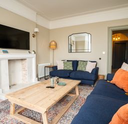 A living room with blue sofas and wooden coffee table at Haulfryn in Barmouth