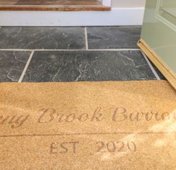 A floor with dark tiles and a welcome mat at Inny Brook Burrow in Davidstow near Camelford