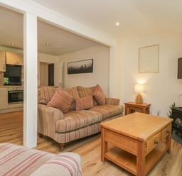A living room with a sofa and coffee table at Chestnut Timber Lodge in Keswick