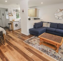 A living room with a sofa and coffee table at Chellowdene Cottage in Falmouth