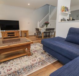 A living room with a sofa and television at Chellowdene Cottage in Falmouth