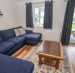 A living room with a sofa and coffee table at Chellowdene Cottage in Falmouth