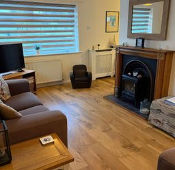 A living room with a sofa and television at Jacuma in Rhosneigr