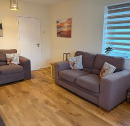 A living room with two sofas and wall art at Jacuma in Rhosneigr