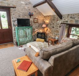 A living room with a sofa and television at Coach House in Haverfordwest near Broad Haven