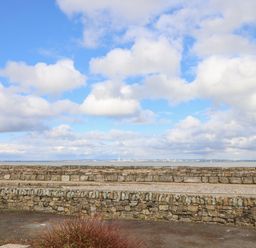 A view of the sea with stone walls and a cloudy sky at Little Beach in Seaview