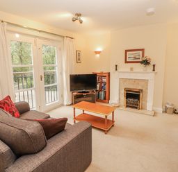 A living room with a television and fireplace at Flat 17 in Keswick