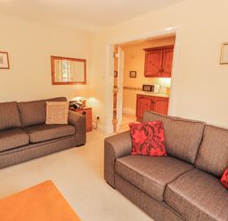 A living room with two sofas and a view to the kitchen at Flat 17 in Keswick