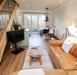 A living room with a sofa and television at Nene's Nest in Alnwick