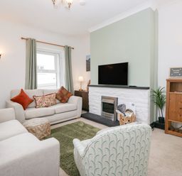 A living room with a sofa and television at 3 Nixon Terrace in Broughton Moor near Maryport
