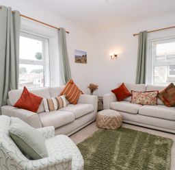 A living room with sofas and a rug at 3 Nixon Terrace Broughton Moor near Maryport