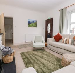 A living room with a sofa and armchair at 3 Nixon Terrace Broughton Moor near Maryport
