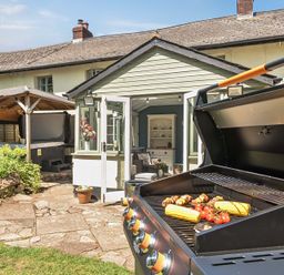 An outdoor area with a grill and vegetables at 2 Pigsfoot Cottages in Ash Thomas near Halberton, Devon