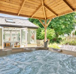 A hot tub with gazebo and surrounding garden at 2 Pigsfoot Cottages Ash Thomas near Halberton, Devon