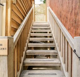 Wooden outdoor staircase with handrails and a sign saying The Rookery at The Rookery in Fulbrook near Burford
