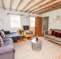 A living room with two sofas an armchair a coffee table and a rug at Heron House in Talley near Llandeilo