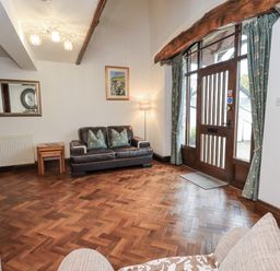 A living room with a sofa and lamp at Horse and Farrier Barn in Newton in Cartmel near Cartmel
