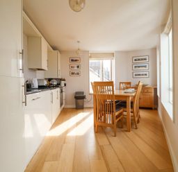 A kitchen with cabinets countertop dining table and chairs at 23 Tibby's Way Southwold