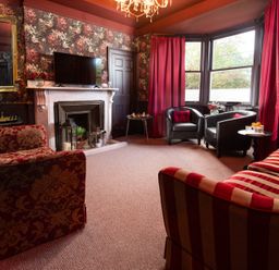 A living room with a sofa, armchairs and a fireplace at Wonderland in Tweedmouth, Berwick-Upon-Tweed