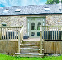 An outdoor area with deck and furniture at Gelli Barn Near Llandeilo