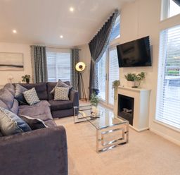 A living room with a sofa and coffee table at Unique Luxury Lodge, 1 Langdale, White Cross Bay near Windermere