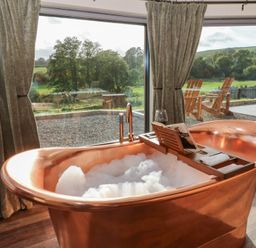 A bathroom with a copper bathtub and a view at Ty Crwn Lampeter