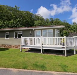 A cabin with a deck and garden at Serenity in Kilgetty