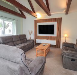 A living room with a sofa and a television at Whitbarrow 24 in Penruddock