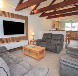 A living room with a sofa and television at Whitbarrow 24 Penruddock