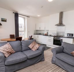 A living room with two sofas and a dining table near a kitchen at 7 Beach View Beaconsfield House in Bridlington
