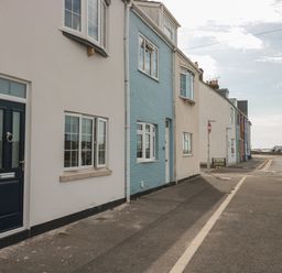 A street with a row of houses in white and blue near the sea at Quay Cottage Sea View in Poole