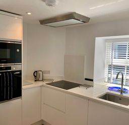 A kitchen with an oven, kettle, sink, and stovetop at Beach Cottage in Cadgwith