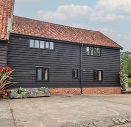 A building with windows and flowers at The Cow Shed in Chediston near Halesworth