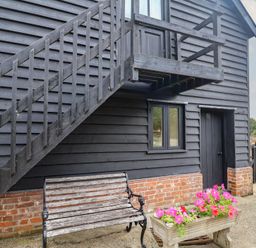 An exterior view with stairs, bench and flowers at The Cow Shed in Chediston near Halesworth