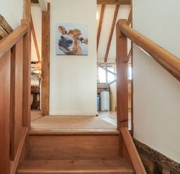 A staircase leading to a wall with a painting at The Cow Shed in Chediston near Halesworth