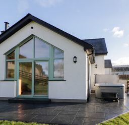 A house with a hot tub on the patio at Y Stabal near Llanilar