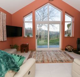 A living room with a sofa and fireplace at Y Stabal near Llanilar