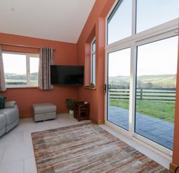 A living room with a sofa and television at Y Stabal near Llanilar