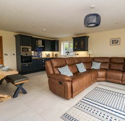 A living room with a sofa and dining table at Y Beudy near Llanilar