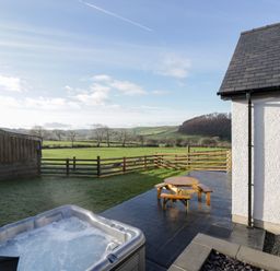 A garden with a hot tub and an outdoor seating area at Beudy near Llanilar