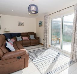 A living room with a sofa and sliding door at Beudy near Llanilar