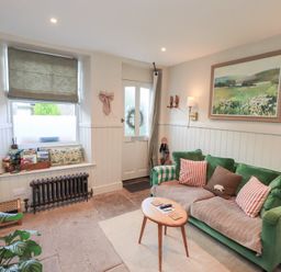 A living room with a sofa and a table at Gosling Cottage in Kendal