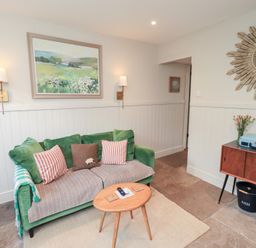 A living room with a sofa and table at Gosling Cottage in Kendal