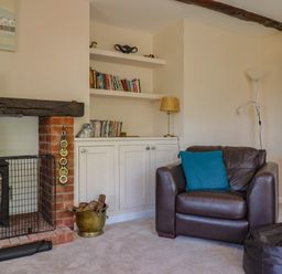 A living room with a fireplace and bookshelf at Woodstock in Chard