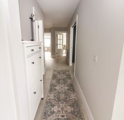 A hallway with a patterned runner rug and white cabinets at 19A Lighthouse Village in Fenit County Kerry