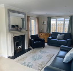 A living room with a fireplace and seating area at 3 Strawberry Close Little Haven near Broad Haven