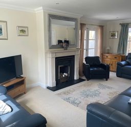 A living room with a fireplace and television at 3 Strawberry Close Little Haven near Broad Haven